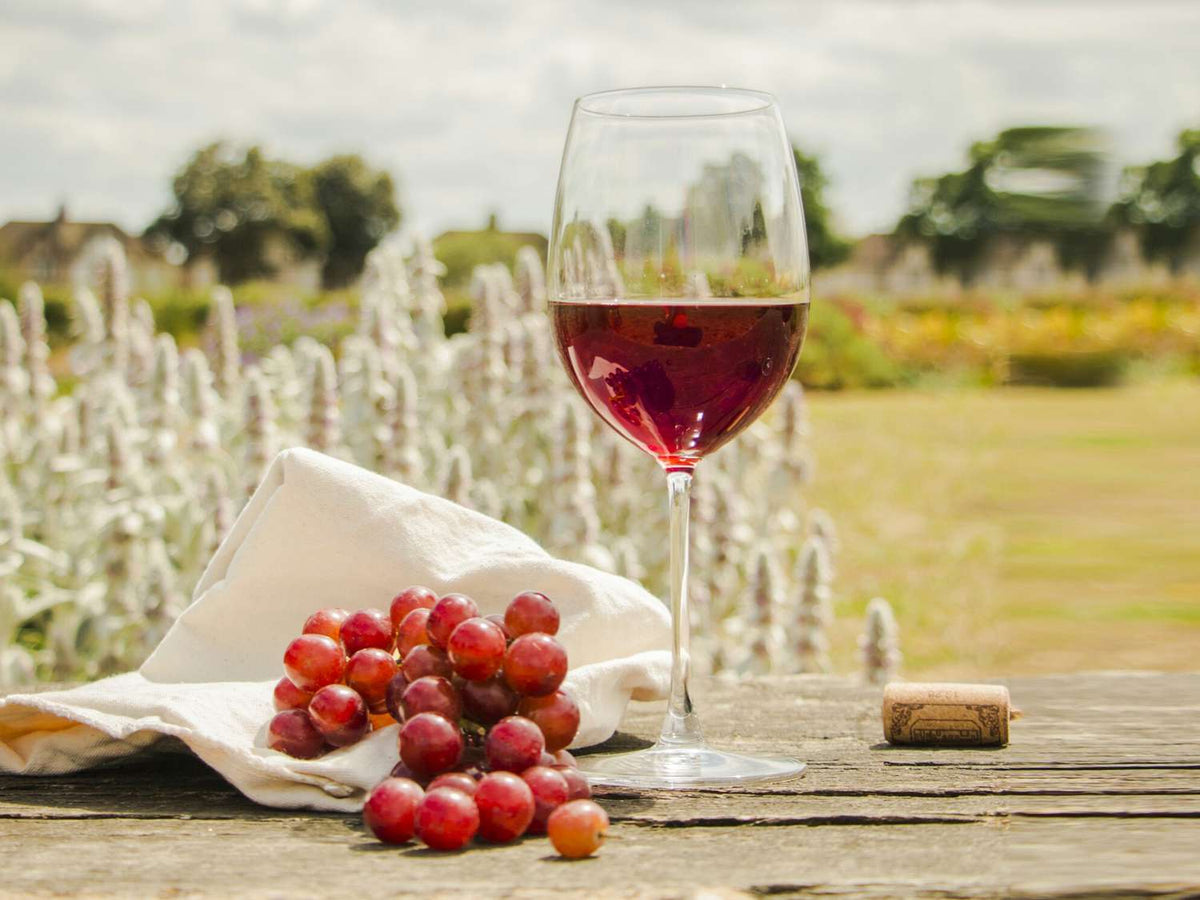 Grapes, a glass of wine and a cork. 